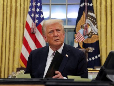 FILE PHOTO: U.S. President Donald Trump signs documents as he issues executive orders and pardons for Jan. 6 defendants in the Oval Office at the White House on Inauguration Day in Washington, U.S., January 20, 2025. REUTERS/Carlos Barria/File Photo